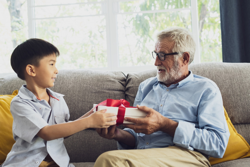 boy giving a gift to his grandfather