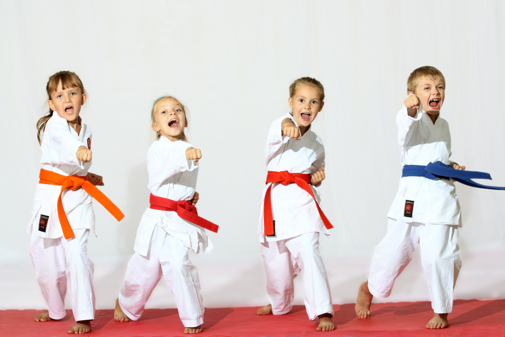 small children in their karate uniform doing karate poses