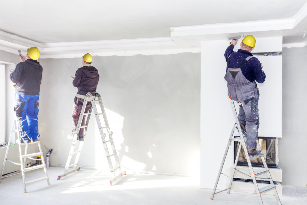 men working in a room repainting
