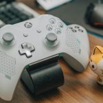 Xbox controller with a cat figurine next to it