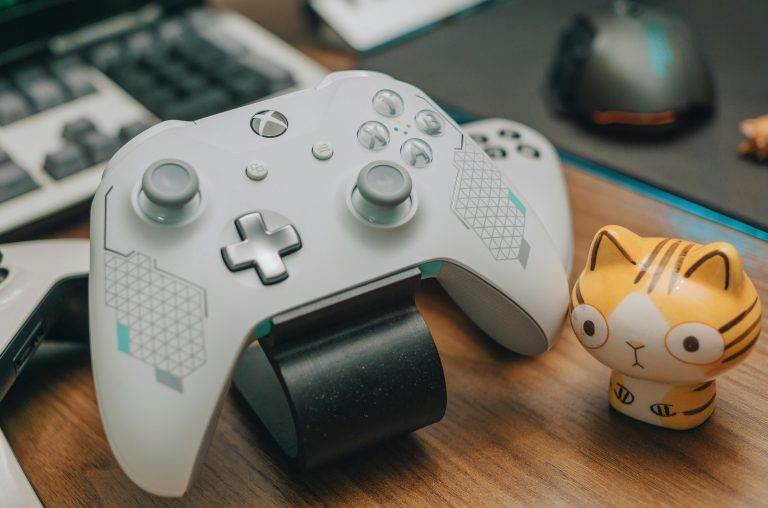 Xbox controller with a cat figurine next to it